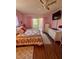 Bright pink bedroom with hardwood floors, sliding doors to a patio, and neutral furniture at 3516 Lake Bayshore Dr # K109, Bradenton, FL 34205
