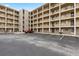 Exterior view of condo building with parking, multiple stories, and balconies under a blue sky at 3516 Lake Bayshore Dr # K109, Bradenton, FL 34205