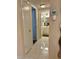 Well-lit hallway featuring tile floors leads to a bathroom with a vanity and modern fixtures at 3516 Lake Bayshore Dr # K109, Bradenton, FL 34205