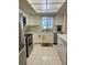 White kitchen cabinets, tile floors, stainless appliances, and countertop space at 3516 Lake Bayshore Dr # K109, Bradenton, FL 34205