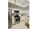 Bright kitchen featuring stainless steel appliances, white cabinets, and a tile floor at 3516 Lake Bayshore Dr # K109, Bradenton, FL 34205