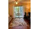 Cozy room featuring a leaf pattern rug, comfortable chair, and outdoor patio access at 3516 Lake Bayshore Dr # K109, Bradenton, FL 34205