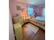 Charming bedroom with pink walls, floral bedding, and natural light from the window at 3516 Lake Bayshore Dr # K109, Bradenton, FL 34205