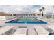 Sparkling community pool with lounge chairs, tables, umbrellas, and lush landscaping at 3516 Lake Bayshore Dr # K109, Bradenton, FL 34205