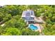 Aerial view of a home nestled among lush trees, featuring a pool and solar panels at 380 Wellington Ave, Oldsmar, FL 34677