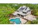 Aerial view featuring a private pool, patio, deck and solar panels surrounded by mature trees at 380 Wellington Ave, Oldsmar, FL 34677