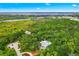 Stunning aerial view of a large home nestled among lush, mature trees near waterfront at 380 Wellington Ave, Oldsmar, FL 34677