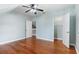 Bright bedroom featuring wood floors, a ceiling fan, and access to closet and stairway at 380 Wellington Ave, Oldsmar, FL 34677