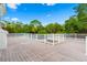 Spacious deck with gray flooring and white railings, offering panoramic views of the surrounding green foliage at 380 Wellington Ave, Oldsmar, FL 34677