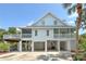 Exterior shot of the light blue multi-story house showcasing the expansive deck, carports, and lush landscaping at 380 Wellington Ave, Oldsmar, FL 34677