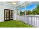 Enclosed porch with turf flooring, ceiling fan, and a tranquil view of the surrounding greenery at 380 Wellington Ave, Oldsmar, FL 34677