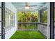 Relaxing screened porch with artificial grass and views of the lush backyard at 380 Wellington Ave, Oldsmar, FL 34677