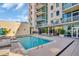 Outdoor pool with lounge chairs, umbrellas and multiple story residences in background at 400 4Th S Ave # 401, St Petersburg, FL 33701