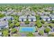 Aerial view of a townhouse community with a tennis court, ample parking, and mature trees at 4002 Carrollwood Palm Ct, Tampa, FL 33624