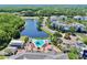 Aerial view of a beautiful community with a pool, clubhouse, and a serene lake with fountain at 4002 Carrollwood Palm Ct, Tampa, FL 33624