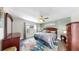 A primary bedroom features hardwood floors, ceiling fan, and neutral colored walls with art and ample natural light at 4002 Carrollwood Palm Ct, Tampa, FL 33624