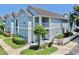 Well-maintained two-story home with a balcony, white trim, and lush green landscaping at 4002 Carrollwood Palm Ct, Tampa, FL 33624