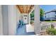Inviting front porch with a white door, seating, and a view of the surrounding neighborhood at 4002 Carrollwood Palm Ct, Tampa, FL 33624