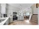 Bright kitchen boasts stainless steel appliances, white cabinets, subway tile backsplash, and hardwood floors at 4002 Carrollwood Palm Ct, Tampa, FL 33624