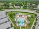 Aerial view of a community pool with lounge chairs, lush landscaping, and a charming cabana at 4002 Carrollwood Palm Ct, Tampa, FL 33624