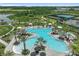Aerial view of a community pool, tennis courts, and a lake at 4257 Rosatti Rd, Wesley Chapel, FL 33543