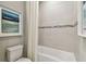 Bathroom with a white tiled shower/tub and white toilet beside a framed picture at 4257 Rosatti Rd, Wesley Chapel, FL 33543