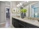 Double vanity with gray countertop and dark cabinets, plus modern fixtures and artwork at 4257 Rosatti Rd, Wesley Chapel, FL 33543