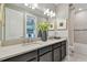 Bathroom double vanity with modern finishes including a gray countertop, dark cabinets, and chrome fixtures at 4257 Rosatti Rd, Wesley Chapel, FL 33543