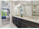 Bathroom featuring dual sinks, granite countertop, modern lighting fixtures, and a doorway to a bedroom at 4257 Rosatti Rd, Wesley Chapel, FL 33543