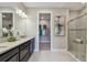 Bathroom featuring double sinks, stylish countertops, a glass-enclosed shower, and access to a walk-in closet at 4257 Rosatti Rd, Wesley Chapel, FL 33543