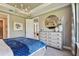 Well-lit bedroom showcasing a blue bedspread, decorative chandelier, and elegant furnishings at 4257 Rosatti Rd, Wesley Chapel, FL 33543