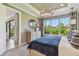 Comfortable bedroom with a blue bedspread, a decorative chandelier, and a large window offering a lush green view at 4257 Rosatti Rd, Wesley Chapel, FL 33543