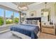 Bright bedroom with a large window, blue quilted bedding, decorative pillows, and stylish decor at 4257 Rosatti Rd, Wesley Chapel, FL 33543