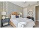 Bedroom featuring geometric wallpaper, a woven headboard, and bright natural light at 4257 Rosatti Rd, Wesley Chapel, FL 33543