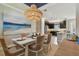 Bright dining area features stylish decor, a woven chandelier, and an adjacent kitchen at 4257 Rosatti Rd, Wesley Chapel, FL 33543