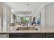 Open-concept kitchen with stainless steel sink, black cabinets, and a bright living area with sliding glass doors at 4257 Rosatti Rd, Wesley Chapel, FL 33543
