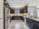 Modern kitchen featuring dark cabinets, stainless steel appliances, granite countertops, and a bright, window-lit space at 4257 Rosatti Rd, Wesley Chapel, FL 33543