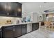 Spacious kitchen with elegant black cabinets, granite counters, subway tile backsplash, and wood-look flooring at 4257 Rosatti Rd, Wesley Chapel, FL 33543