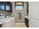 Well-organized laundry room with modern washer, dryer, and ample storage cabinets at 4257 Rosatti Rd, Wesley Chapel, FL 33543