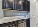 Laundry room with white sink, countertops, stainless faucet and sleek, dark cabinetry at 4257 Rosatti Rd, Wesley Chapel, FL 33543