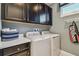 A laundry room with modern washer and dryer, sleek cabinetry and bright countertops at 4257 Rosatti Rd, Wesley Chapel, FL 33543
