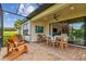 Covered patio with brick flooring, ceiling fan, dining set and outdoor lounge chairs at 4257 Rosatti Rd, Wesley Chapel, FL 33543