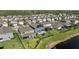 Beautiful aerial view of the houses in a community with a pond and solar panels at 4583 Emprise Way, Land O Lakes, FL 34638