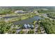 Aerial view of the community with a lake, clubhouse, and surrounding trees at 4583 Emprise Way, Land O Lakes, FL 34638