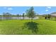Expansive backyard with a lush lawn, tranquil lake view, and secure fencing creating a serene outdoor space at 4583 Emprise Way, Land O Lakes, FL 34638