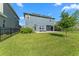 Spacious backyard with a covered patio, furniture, and a lush lawn at 4583 Emprise Way, Land O Lakes, FL 34638