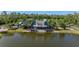 Picturesque home with a deck overlooking a serene lake, surrounded by lush greenery and mature trees at 4583 Emprise Way, Land O Lakes, FL 34638