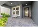 Charming front porch with stone-paved walkway, white bench, and view of the front door at 4583 Emprise Way, Land O Lakes, FL 34638
