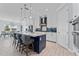 Open-concept kitchen with an island, barstool seating, and white countertops with a blue island base at 4583 Emprise Way, Land O Lakes, FL 34638
