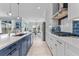 Modern kitchen with stainless steel appliances, a blue backsplash, and a breakfast bar with pendant lighting at 4583 Emprise Way, Land O Lakes, FL 34638